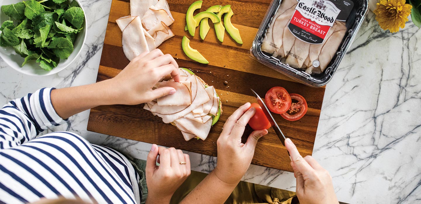 preparing turkey sandwich with tomato